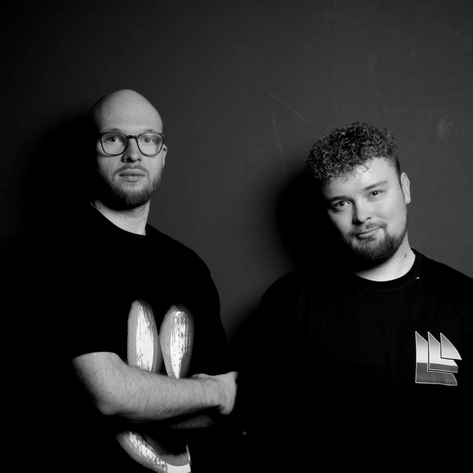 Portrait of DJ duo Shift & Palm against a dark wall